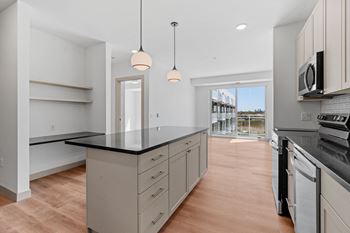 a kitchen with a large island and a door to a balcony